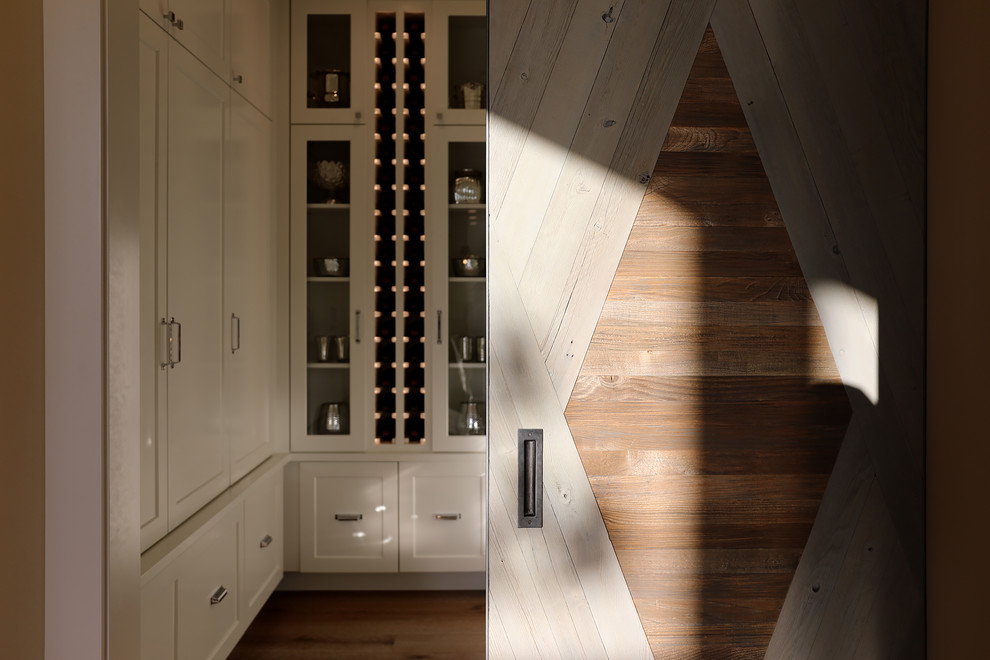 Design ideas for a small country wine cellar in Portland with medium hardwood floors, display racks and beige floor.