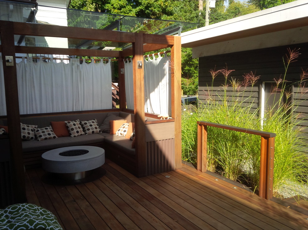 Mid-sized transitional backyard deck photo in Vancouver with a fire pit and a pergola