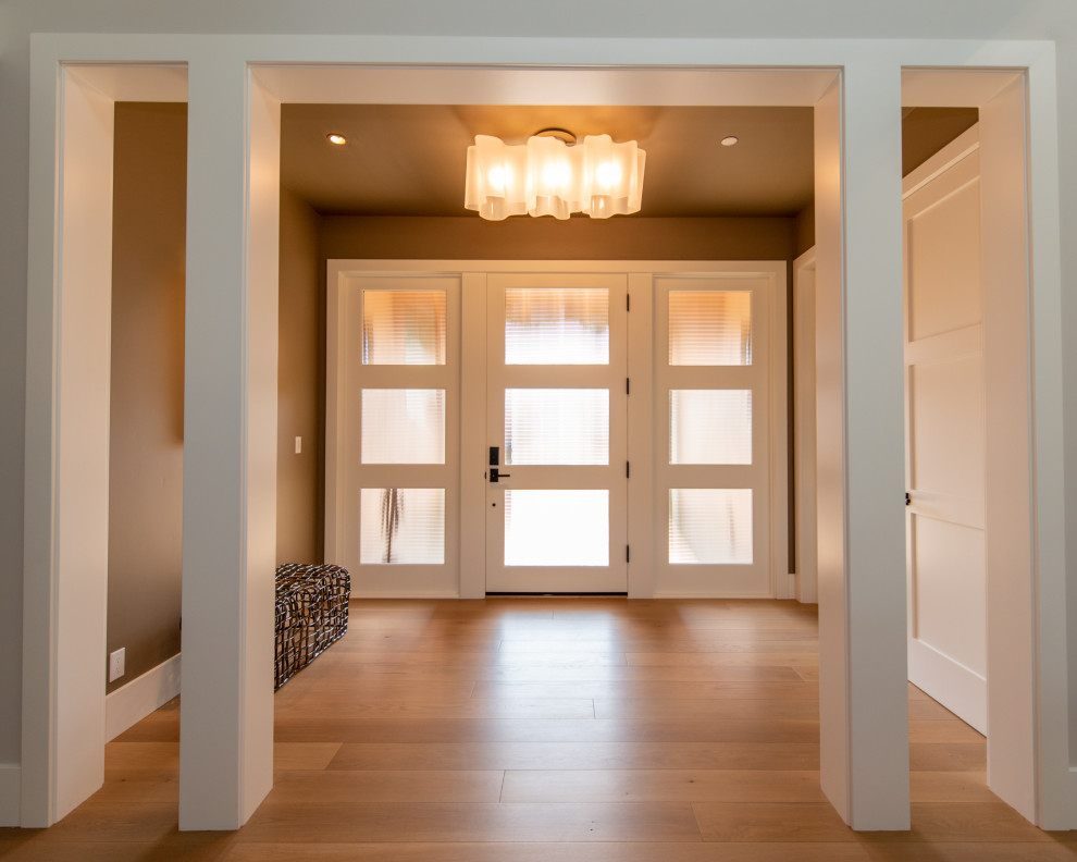 Geräumiges Landhaus Foyer mit hellem Holzboden, Einzeltür, weißer Haustür, braunem Boden, freigelegten Dachbalken, Wandgestaltungen und brauner Wandfarbe in San Francisco