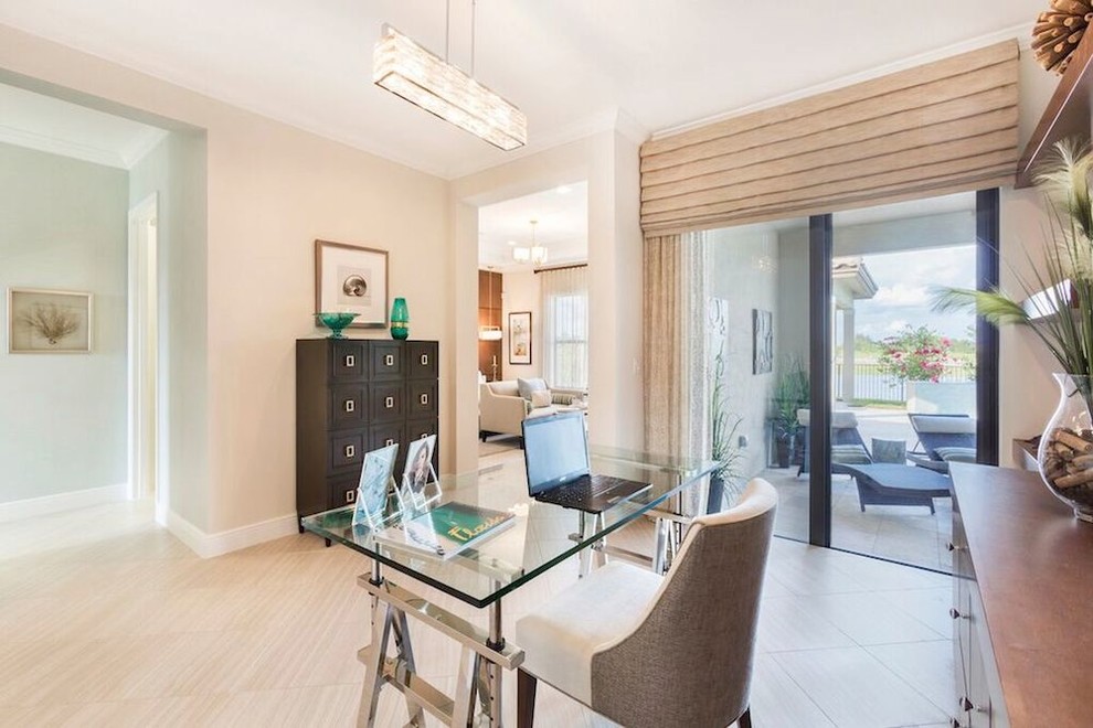 This is an example of a mid-sized beach style home office in Miami with beige walls, porcelain floors and a freestanding desk.