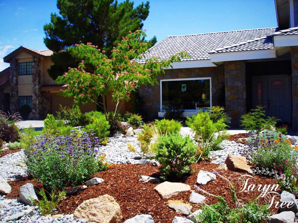Mid-sized and desert look mediterranean front yard full sun xeriscape in Los Angeles with river rock for summer.