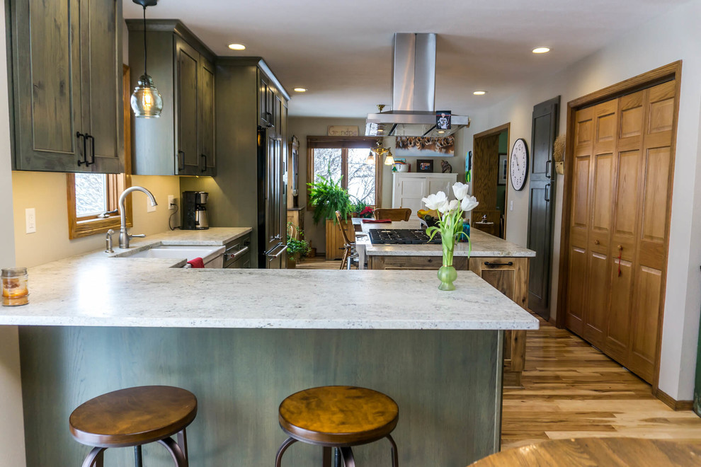 Large mountain style light wood floor and brown floor open concept kitchen photo with beaded inset cabinets, distressed cabinets, granite countertops, an island and white countertops