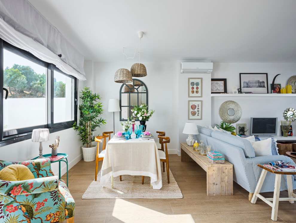 Photo of a mid-sized beach style open plan dining in Malaga with white walls.