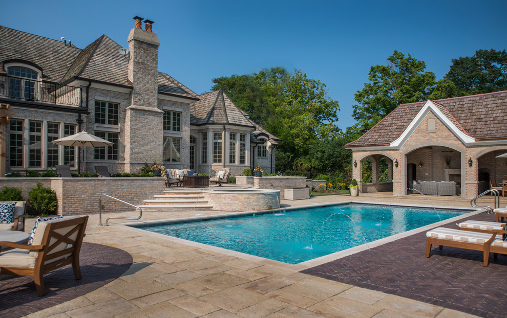 Photo of a mid-sized traditional backyard rectangular lap pool in Chicago with a hot tub and concrete pavers.