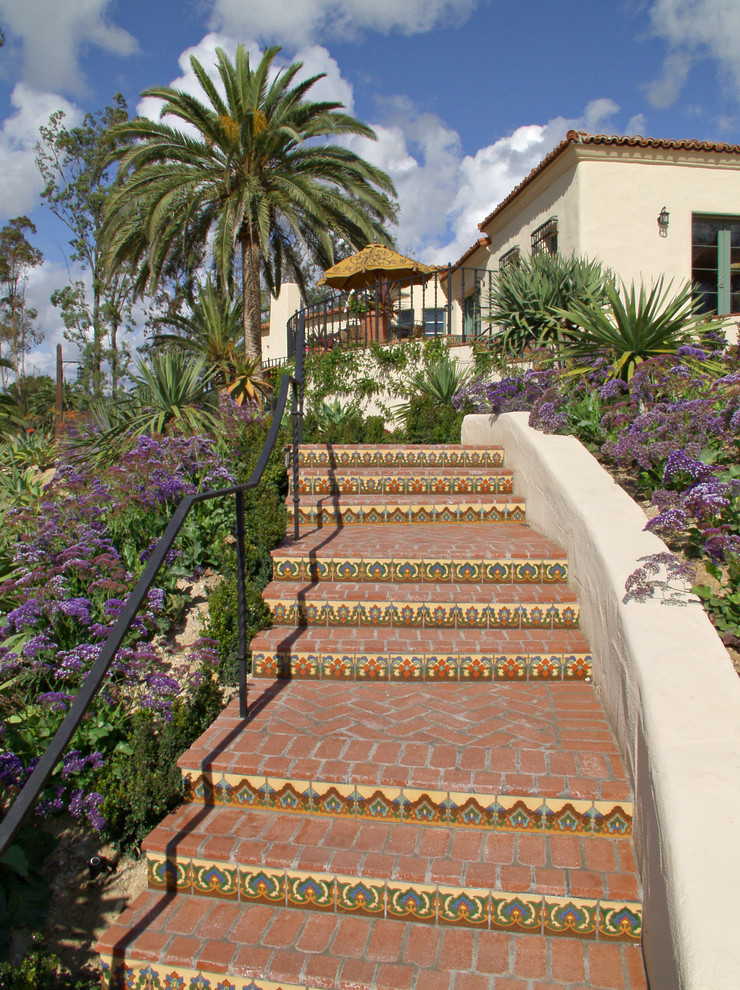This is an example of a mid-sized mediterranean backyard patio in San Diego with a container garden, brick pavers and no cover.