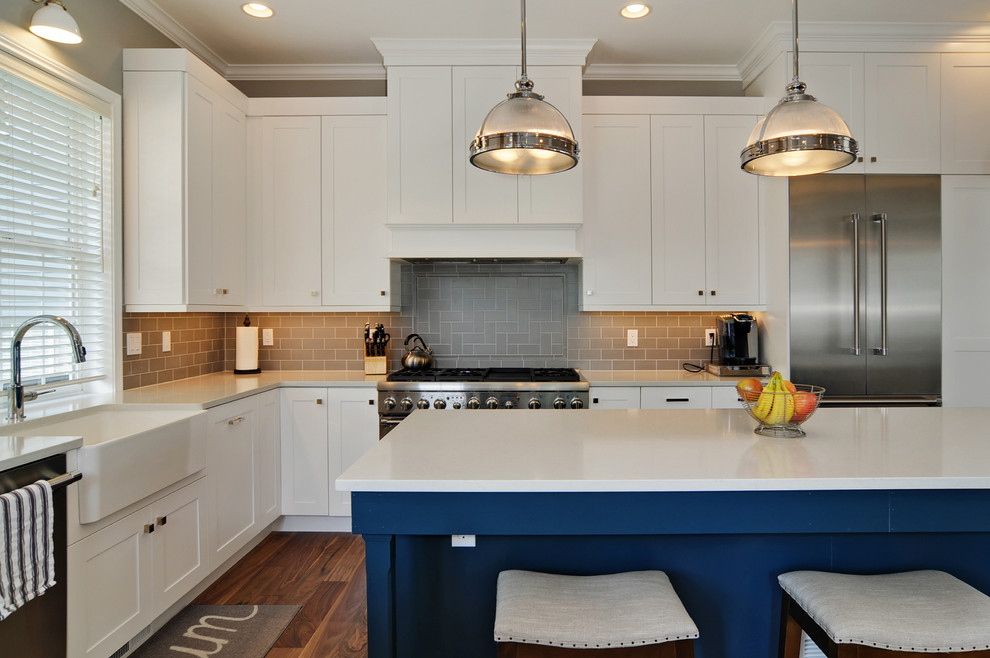 Inspiration for a large transitional l-shaped open plan kitchen in Seattle with a farmhouse sink, shaker cabinets, white cabinets, quartz benchtops, grey splashback, subway tile splashback, stainless steel appliances, dark hardwood floors and with island.
