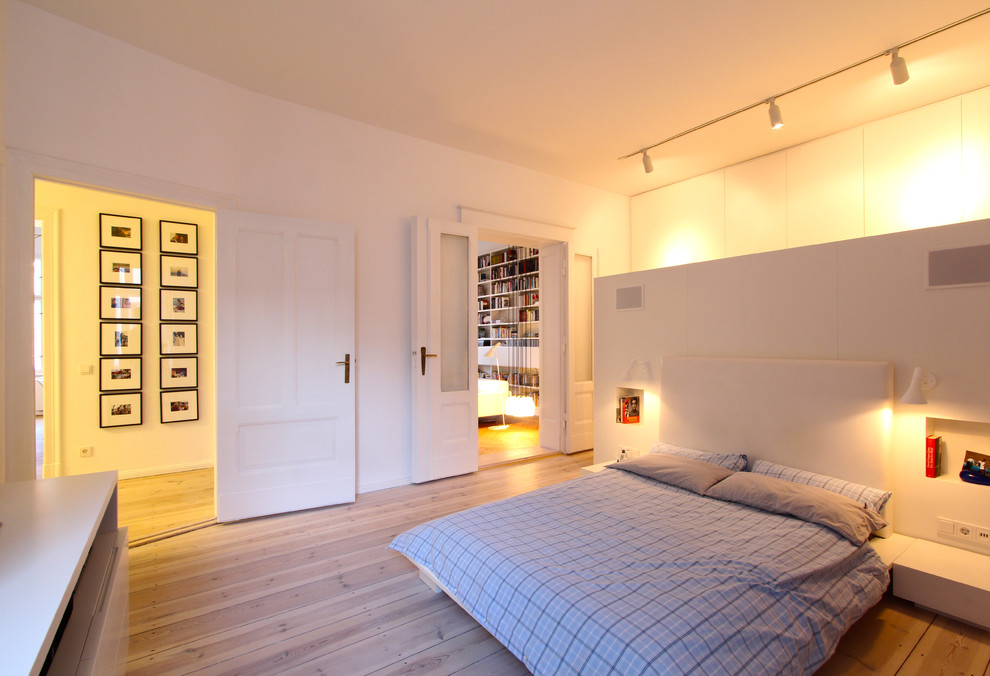 Photo of a large scandinavian master bedroom in Berlin with white walls, light hardwood floors and no fireplace.