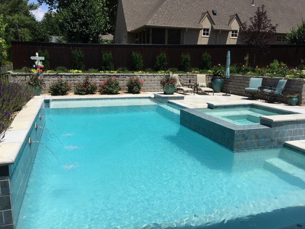 Example of a large transitional backyard concrete paver and rectangular hot tub design