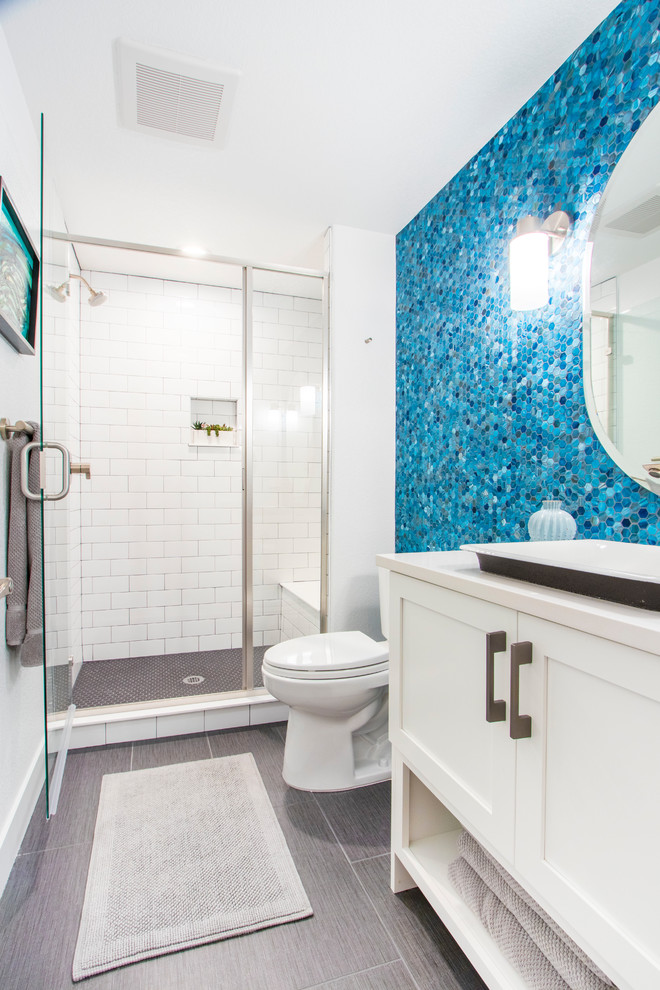 Alcove shower - transitional 3/4 blue tile and mosaic tile gray floor alcove shower idea in Denver with shaker cabinets, white cabinets, a two-piece toilet, white walls, a drop-in sink, a hinged shower door and white countertops