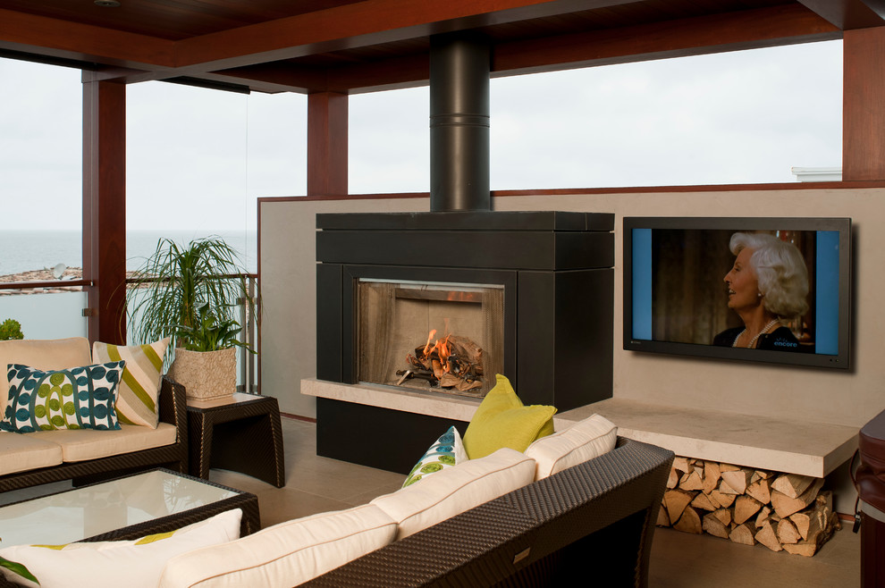 Photo of a contemporary verandah in Los Angeles with a fire feature and a roof extension.
