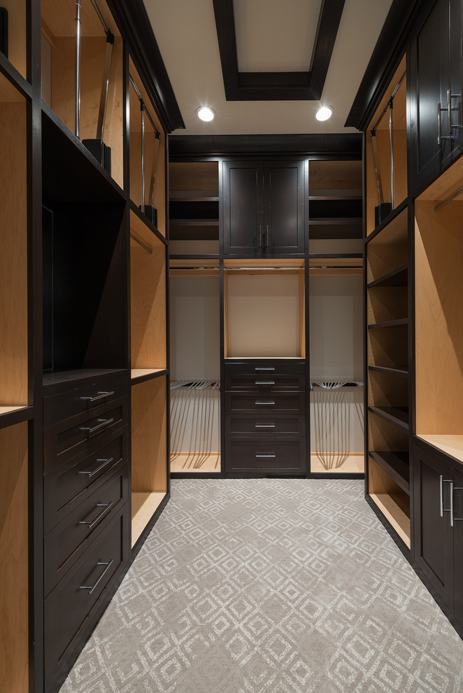 Photo of a mid-sized modern men's walk-in wardrobe in Salt Lake City with recessed-panel cabinets, dark wood cabinets and carpet.