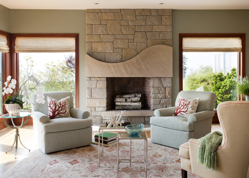 Photo of a beach style living room in Boston with green walls and a stone fireplace surround.