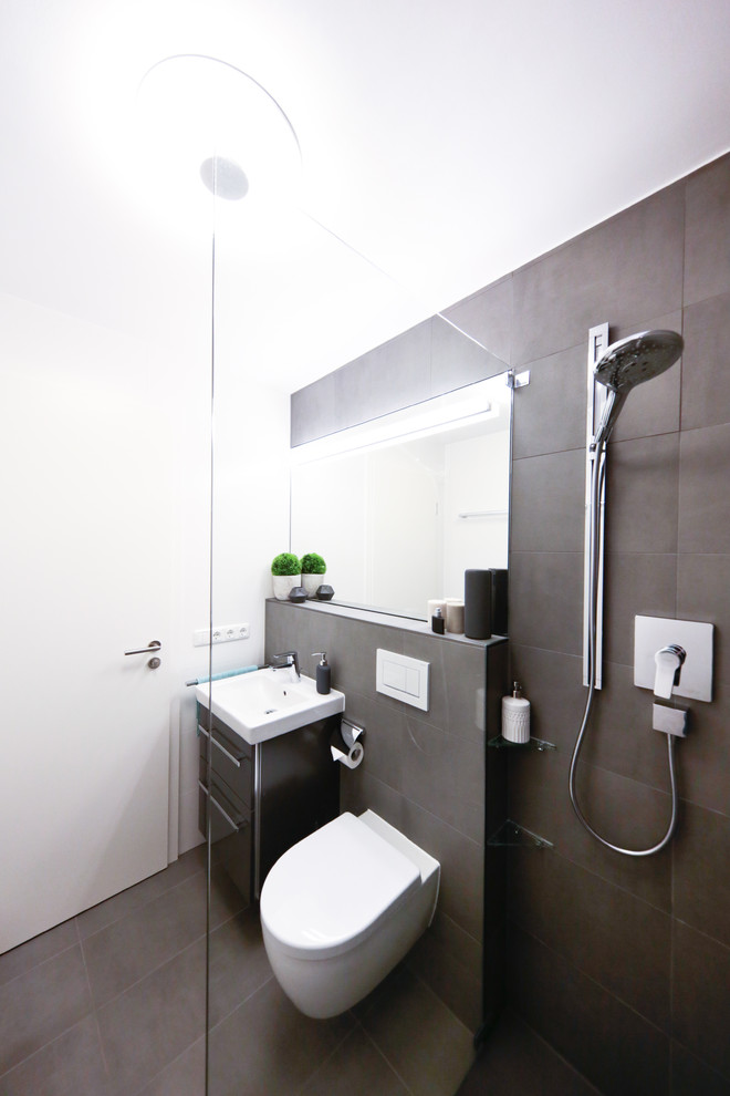 Inspiration for a small contemporary 3/4 bathroom in Munich with flat-panel cabinets, brown cabinets, a curbless shower, a wall-mount toilet, brown tile, cement tile, white walls, cement tiles, a vessel sink, brown floor and an open shower.