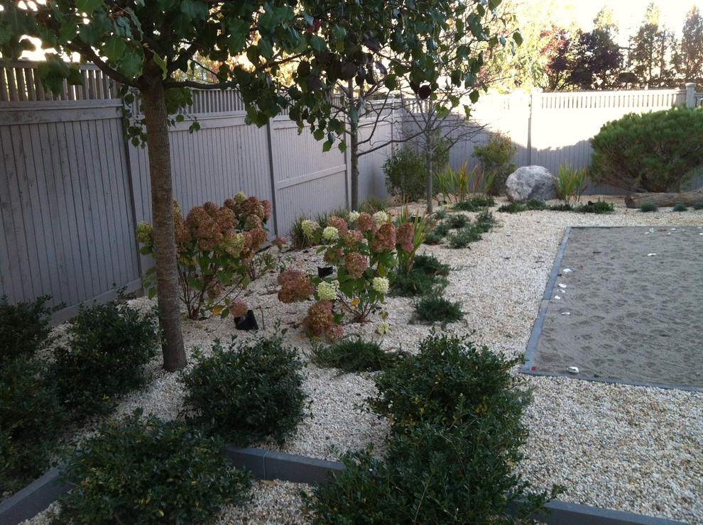 Photo of a small beach style side yard full sun formal garden in New York with natural stone pavers and a water feature.