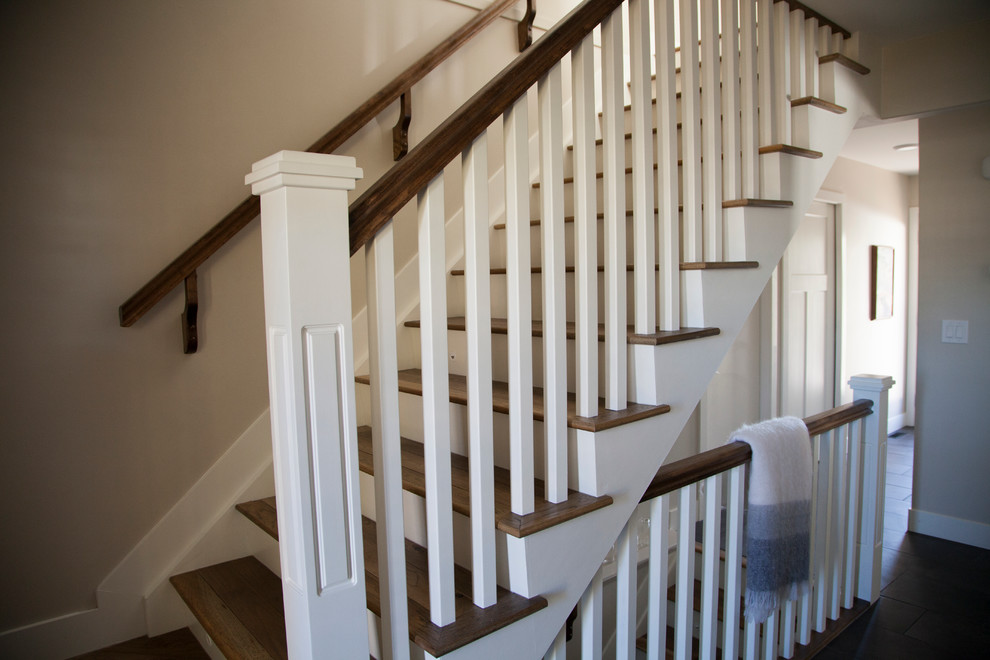 Mid-sized transitional wood straight staircase in Edmonton with painted wood risers.