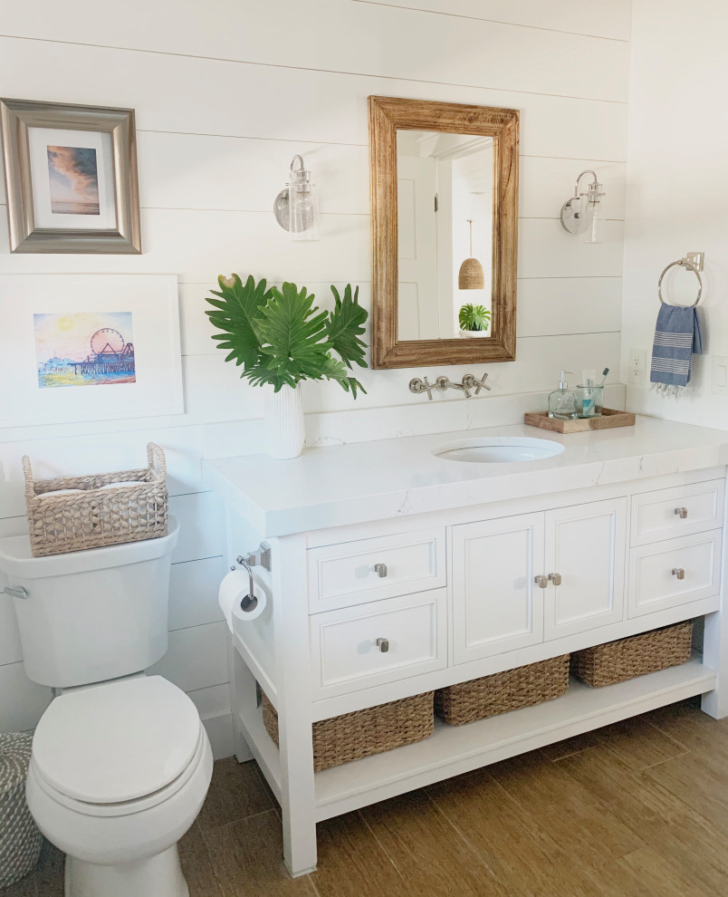 Design ideas for a mid-sized beach style 3/4 bathroom in Orlando with recessed-panel cabinets, white cabinets, a two-piece toilet, white walls, an undermount sink, beige floor, white benchtops, a single vanity, a built-in vanity and planked wall panelling.