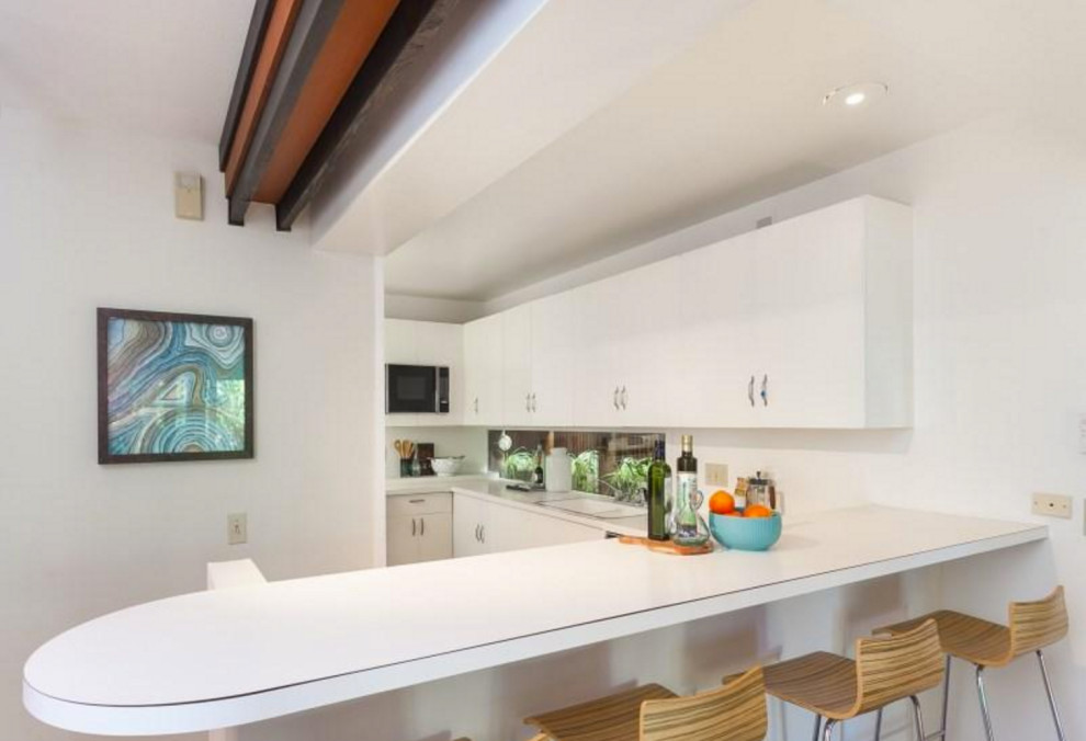 Inspiration for a medium sized modern l-shaped open plan kitchen in Manchester with metallic splashback, mirror splashback, an island and white worktops.
