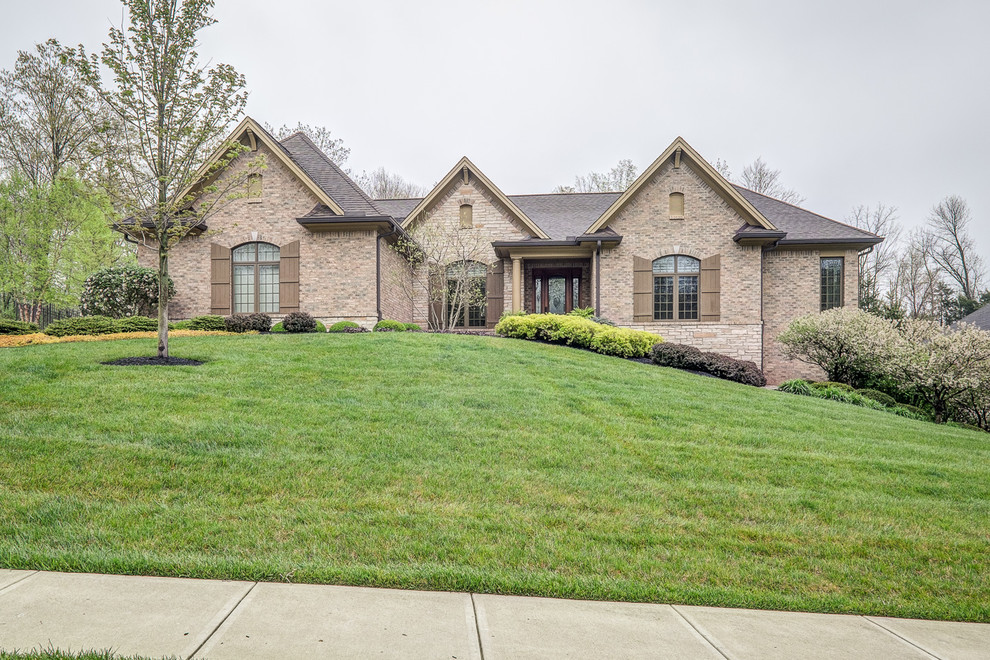 Inspiration for a large transitional beige one-story brick exterior home remodel