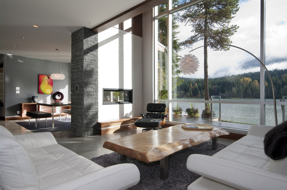 Contemporary open concept living room in Vancouver with concrete floors and a two-sided fireplace.