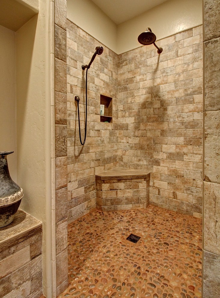 Example of a mid-sized mountain style master stone tile pebble tile floor walk-in shower design in Phoenix with beige walls