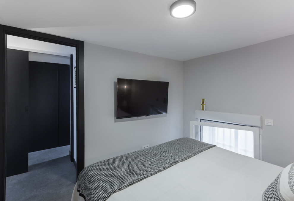На фото: маленькая хозяйская спальня в стиле лофт с серыми стенами, полом из винила, серым полом и обоями на стенах для на участке и в саду с