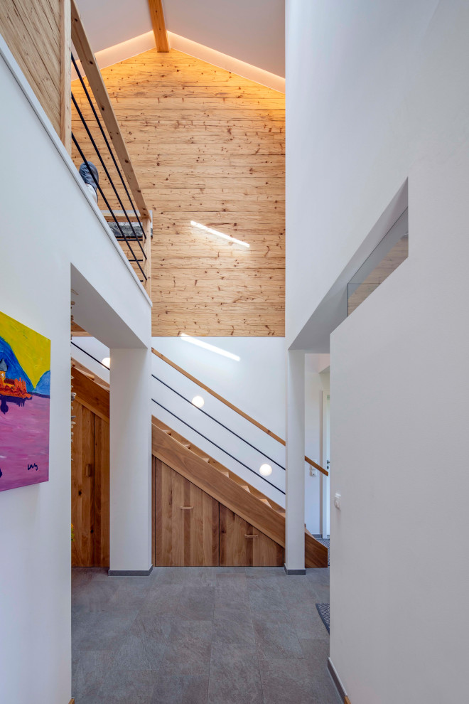 Country Flur mit weißer Wandfarbe, grauem Boden und Holzwänden in München