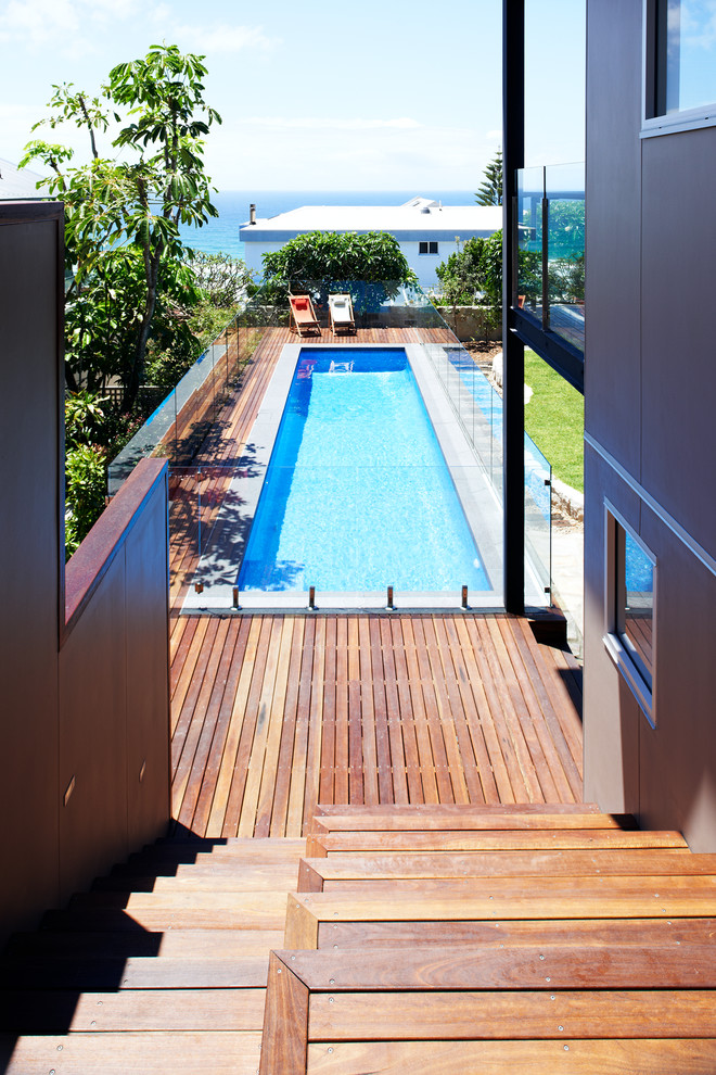 This is an example of a mid-sized contemporary backyard rectangular lap pool in Sydney with decking.