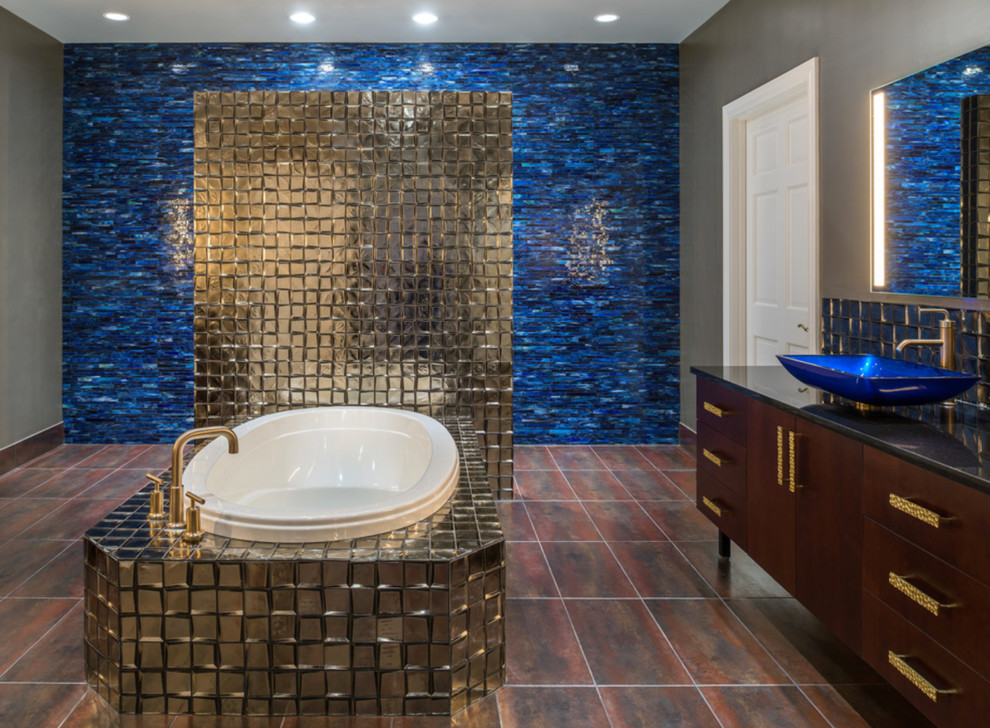 Photo of a mid-sized eclectic master bathroom in St Louis with flat-panel cabinets, dark wood cabinets, a drop-in tub, beige tile, metal tile, beige walls, porcelain floors, a vessel sink, engineered quartz benchtops, brown floor and black benchtops.