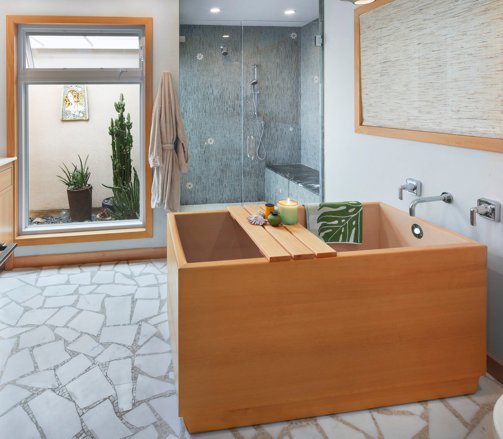 Photo of a mid-sized contemporary master bathroom in Orange County with shaker cabinets, light wood cabinets, a japanese tub, a curbless shower, a one-piece toilet, green tile, mosaic tile, green walls, marble floors, an undermount sink, engineered quartz benchtops, white floor, a hinged shower door and beige benchtops.