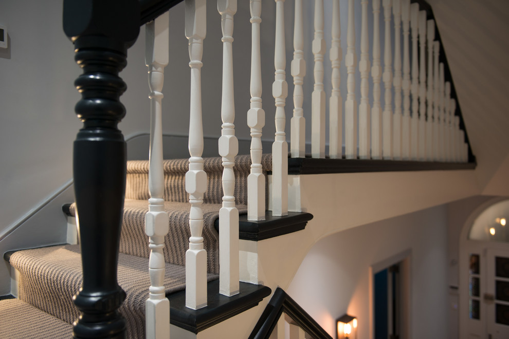 Expansive traditional wood straight staircase in London with wood risers and wood railing.