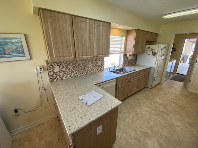 Enclosed kitchen - mid-sized enclosed kitchen idea with raised-panel cabinets, light wood cabinets and a peninsula