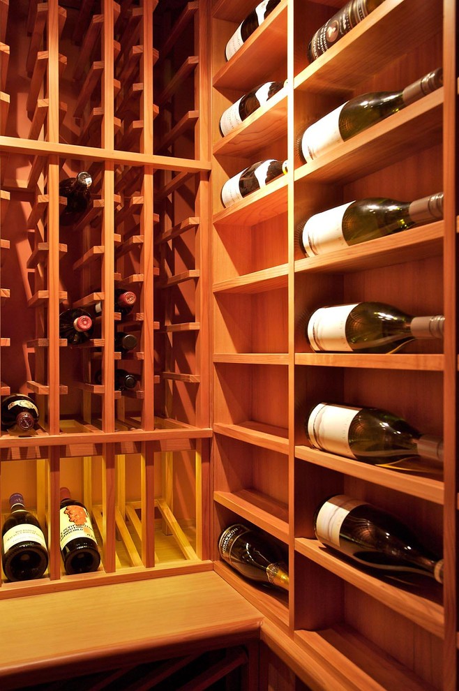 Photo of a small traditional wine cellar in Calgary with dark hardwood floors and storage racks.
