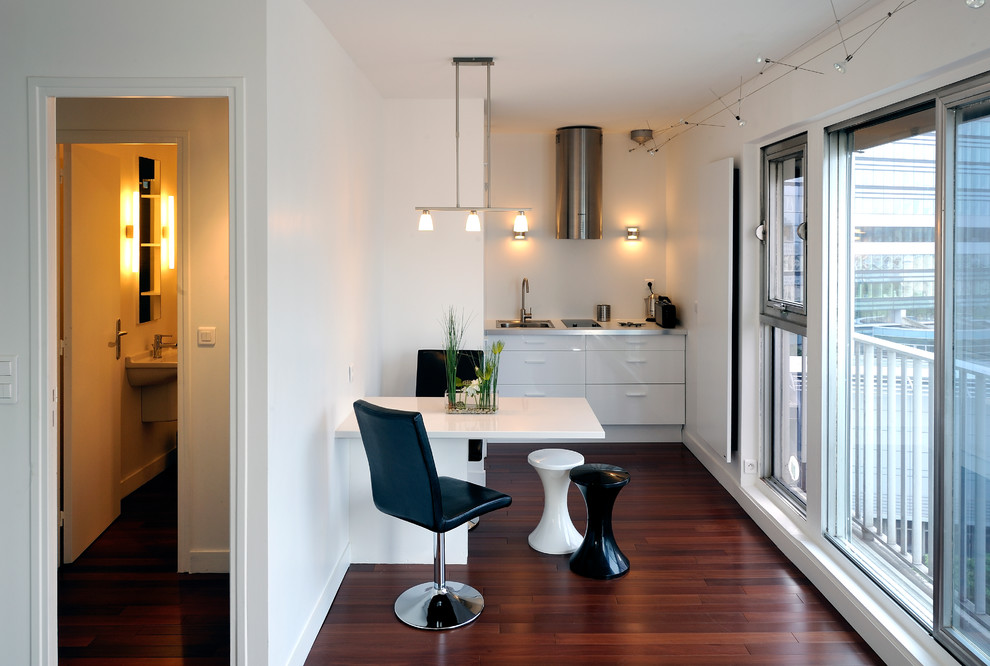 Inspiration for a small contemporary single-wall eat-in kitchen in Paris with a drop-in sink, flat-panel cabinets, white cabinets, stainless steel benchtops, panelled appliances, dark hardwood floors and no island.