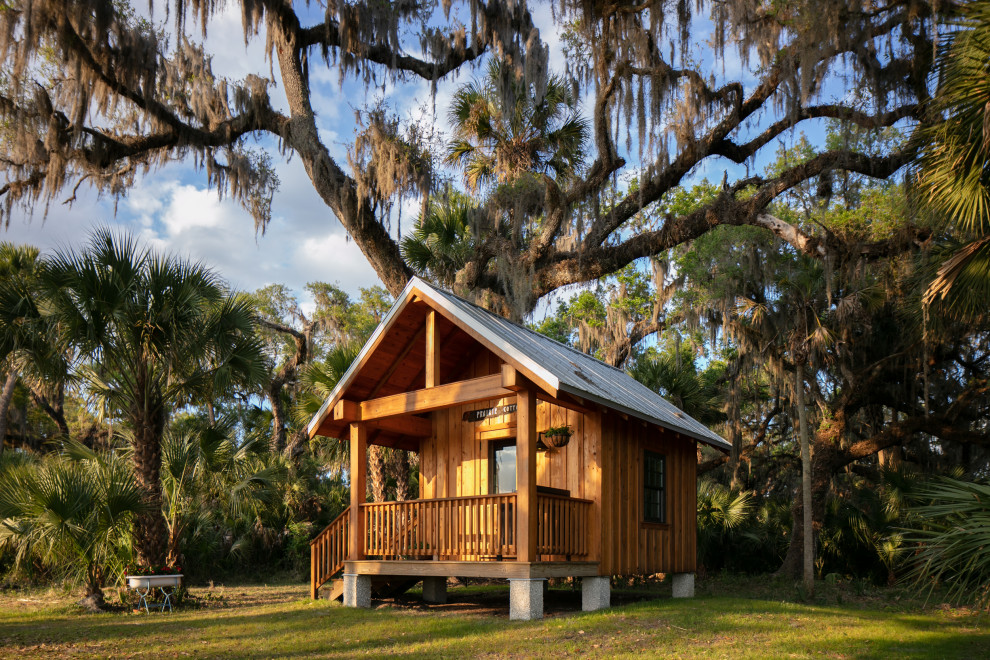 Kleines, Einstöckiges Landhausstil Haus mit brauner Fassadenfarbe, Satteldach, Blechdach, grauem Dach und Wandpaneelen in Tampa