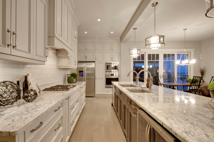 Open concept kitchen - mid-sized transitional l-shaped light wood floor open concept kitchen idea in Calgary with an undermount sink, recessed-panel cabinets, dark wood cabinets, granite countertops, white backsplash, ceramic backsplash, stainless steel appliances and an island