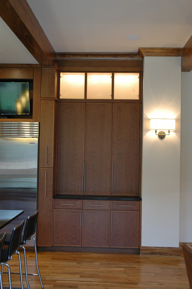Transitional u-shaped eat-in kitchen photo with an undermount sink, flat-panel cabinets, laminate countertops, white backsplash and stainless steel appliances
