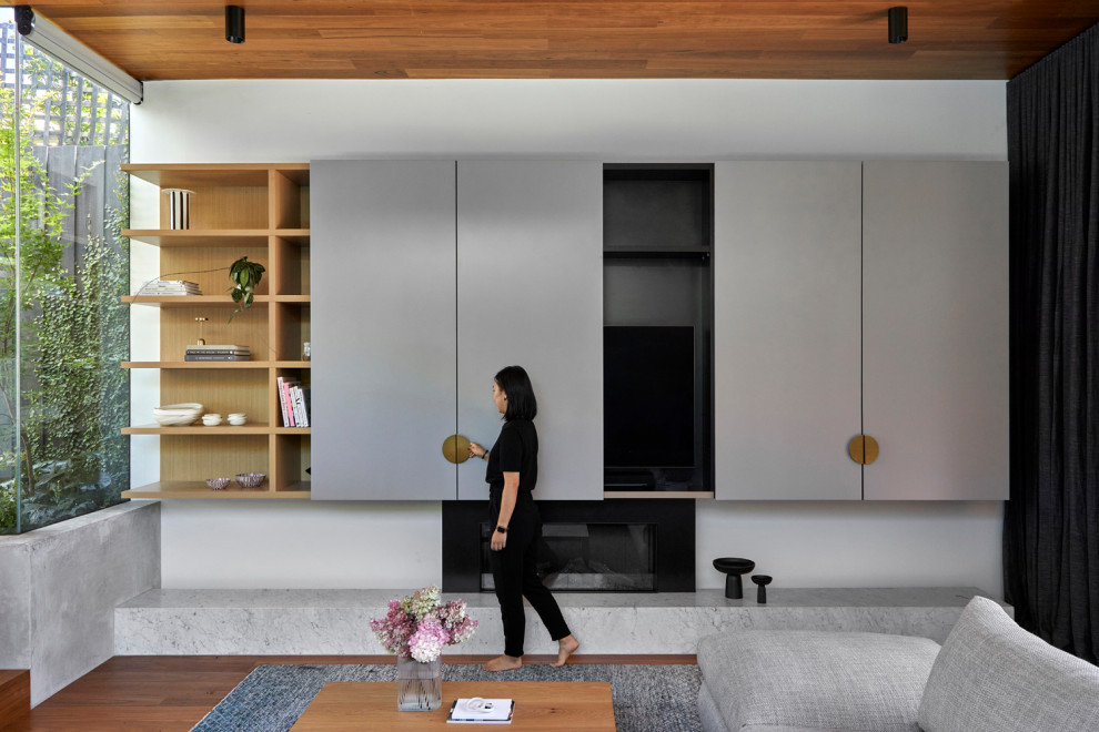 Cette photo montre une salle de séjour tendance de taille moyenne et ouverte avec un mur blanc, un sol en bois brun, une cheminée standard, un manteau de cheminée en métal, un téléviseur dissimulé et un plafond en lambris de bois.