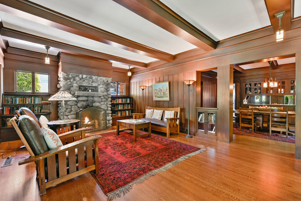 This is an example of a large arts and crafts formal enclosed living room in San Francisco with multi-coloured walls, a standard fireplace, a stone fireplace surround and beige floor.