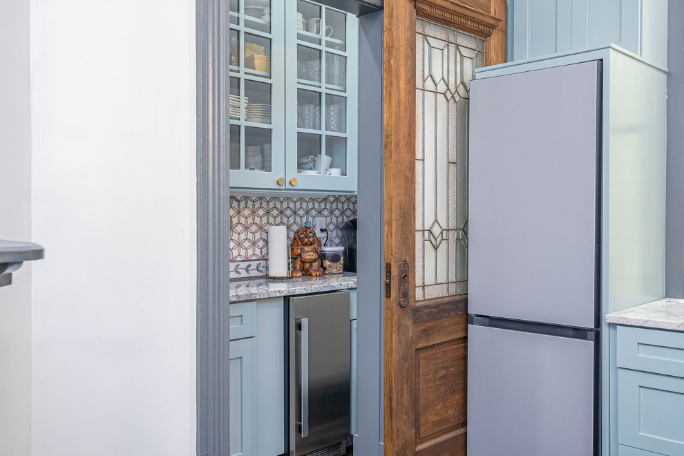 Eat-in kitchen - large transitional galley dark wood floor and black floor eat-in kitchen idea with a farmhouse sink, shaker cabinets, blue cabinets, granite countertops, blue backsplash, ceramic backsplash, colored appliances, an island and multicolored countertops