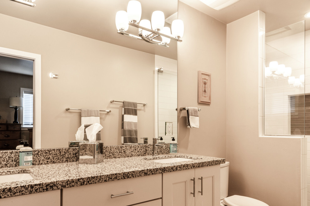 Example of a large transitional medium tone wood floor and red floor open concept kitchen design in Phoenix with an undermount sink, shaker cabinets, white cabinets, granite countertops, multicolored backsplash, granite backsplash, stainless steel appliances, an island and multicolored countertops
