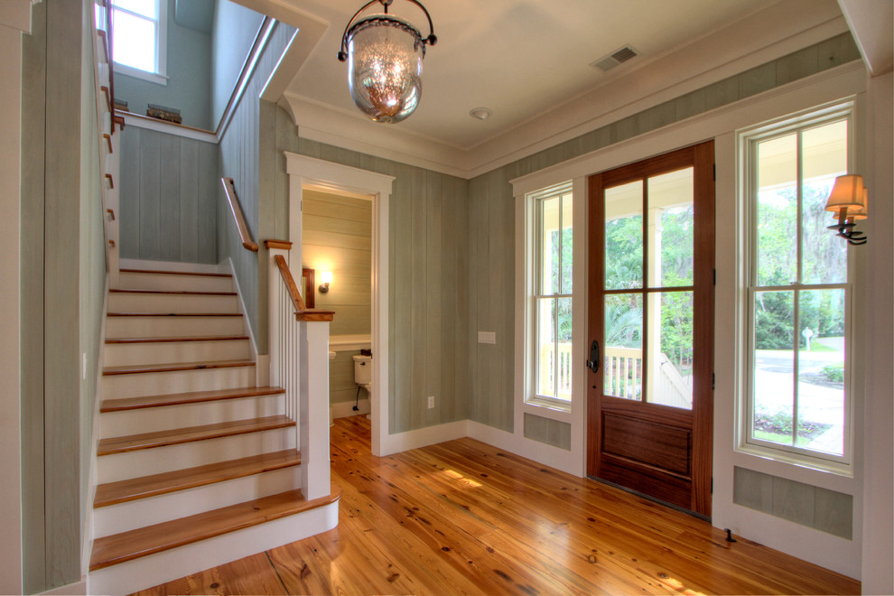 This is an example of a large beach style entryway in Atlanta with green walls, light hardwood floors and a medium wood front door.