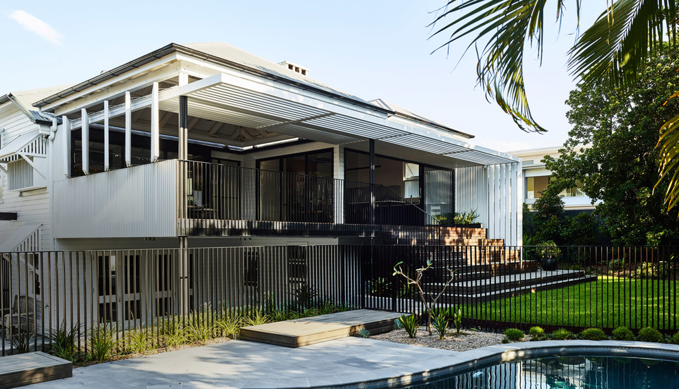 Photo of a contemporary two-storey white house exterior in Brisbane with a hip roof and a metal roof.