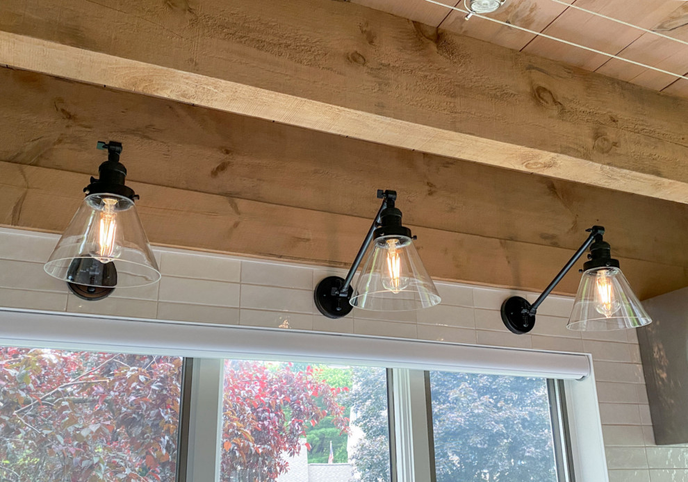 Kitchen - transitional l-shaped light wood floor and exposed beam kitchen idea in Boston with a farmhouse sink, shaker cabinets, gray cabinets, quartz countertops, white backsplash, ceramic backsplash, paneled appliances, an island and white countertops