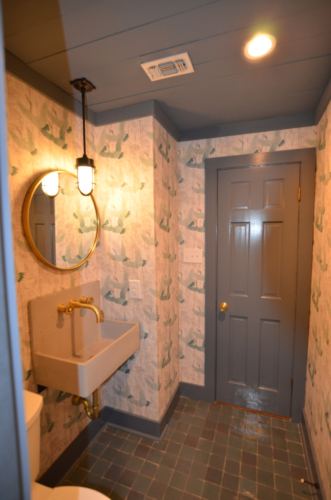 This is an example of a small country 3/4 wet room bathroom in New Orleans with open cabinets, grey cabinets, a two-piece toilet, gray tile, terra-cotta tile, white walls, cement tiles, a wall-mount sink, concrete benchtops, grey floor, a hinged shower door, grey benchtops, a single vanity, a floating vanity, timber and wallpaper.