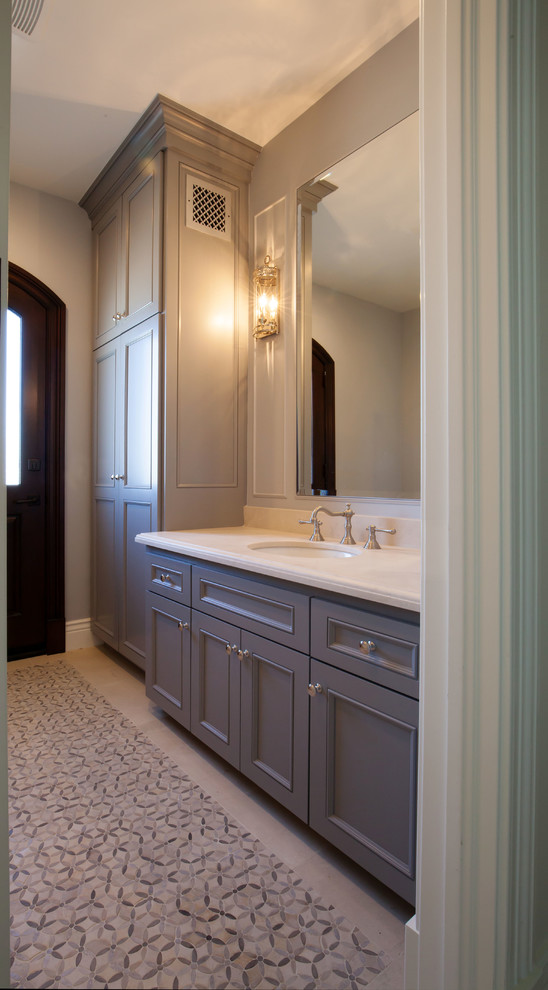 Photo of a mid-sized traditional 3/4 bathroom in Los Angeles with an undermount sink, recessed-panel cabinets, grey cabinets, limestone benchtops, an alcove shower, a two-piece toilet, gray tile, mosaic tile, grey walls and mosaic tile floors.