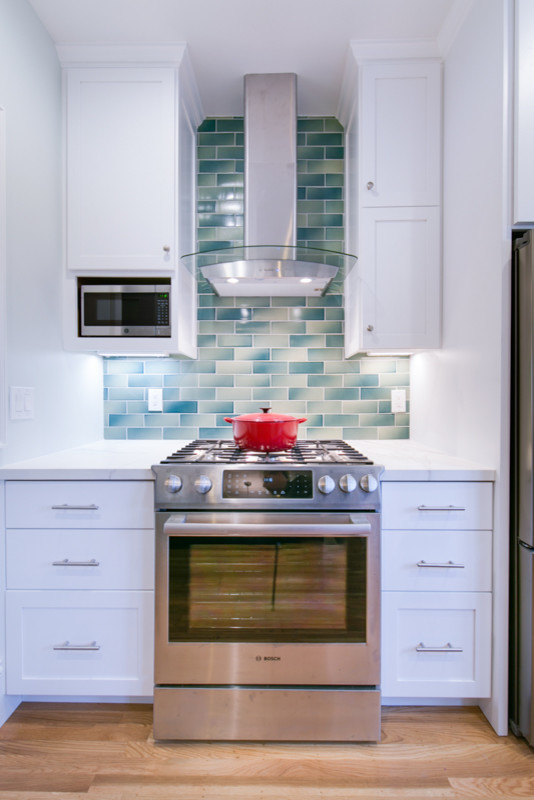 Inspiration for an arts and crafts kitchen in San Francisco with a single-bowl sink, raised-panel cabinets, blue cabinets, blue splashback, subway tile splashback, stainless steel appliances, with island and white benchtop.