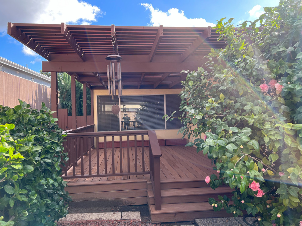 Mid-sized traditional backyard and ground level deck in San Francisco with a pergola and wood railing.