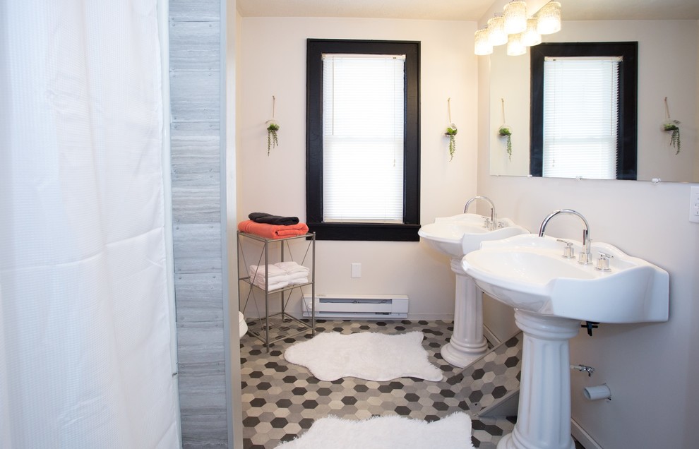 Small transitional gray tile vinyl floor and gray floor alcove bathtub photo with furniture-like cabinets, black cabinets, a two-piece toilet, white walls and a pedestal sink