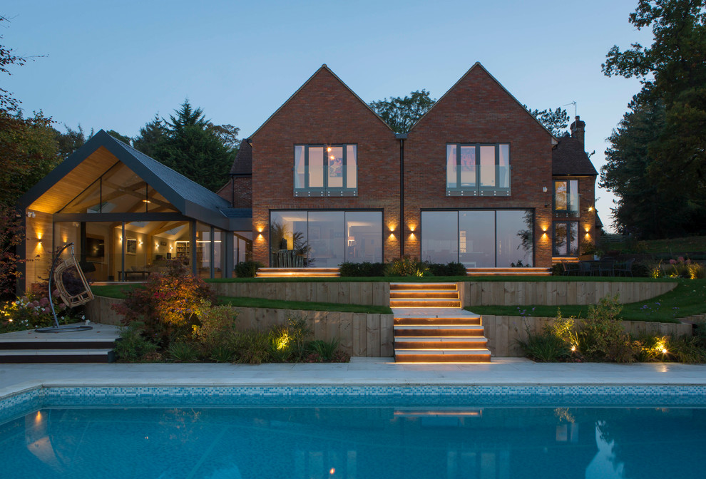 This is an example of a large contemporary two-storey brick red house exterior in Buckinghamshire.