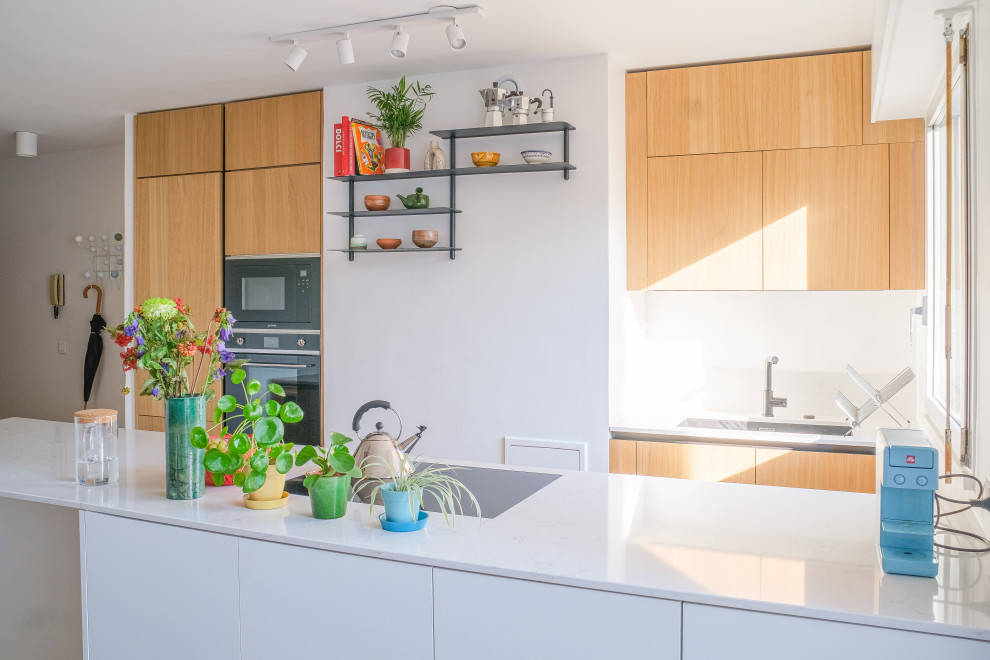 Aménagement d'une cuisine parallèle, encastrable et blanche et bois moderne avec un plan de travail en quartz et un plan de travail blanc.